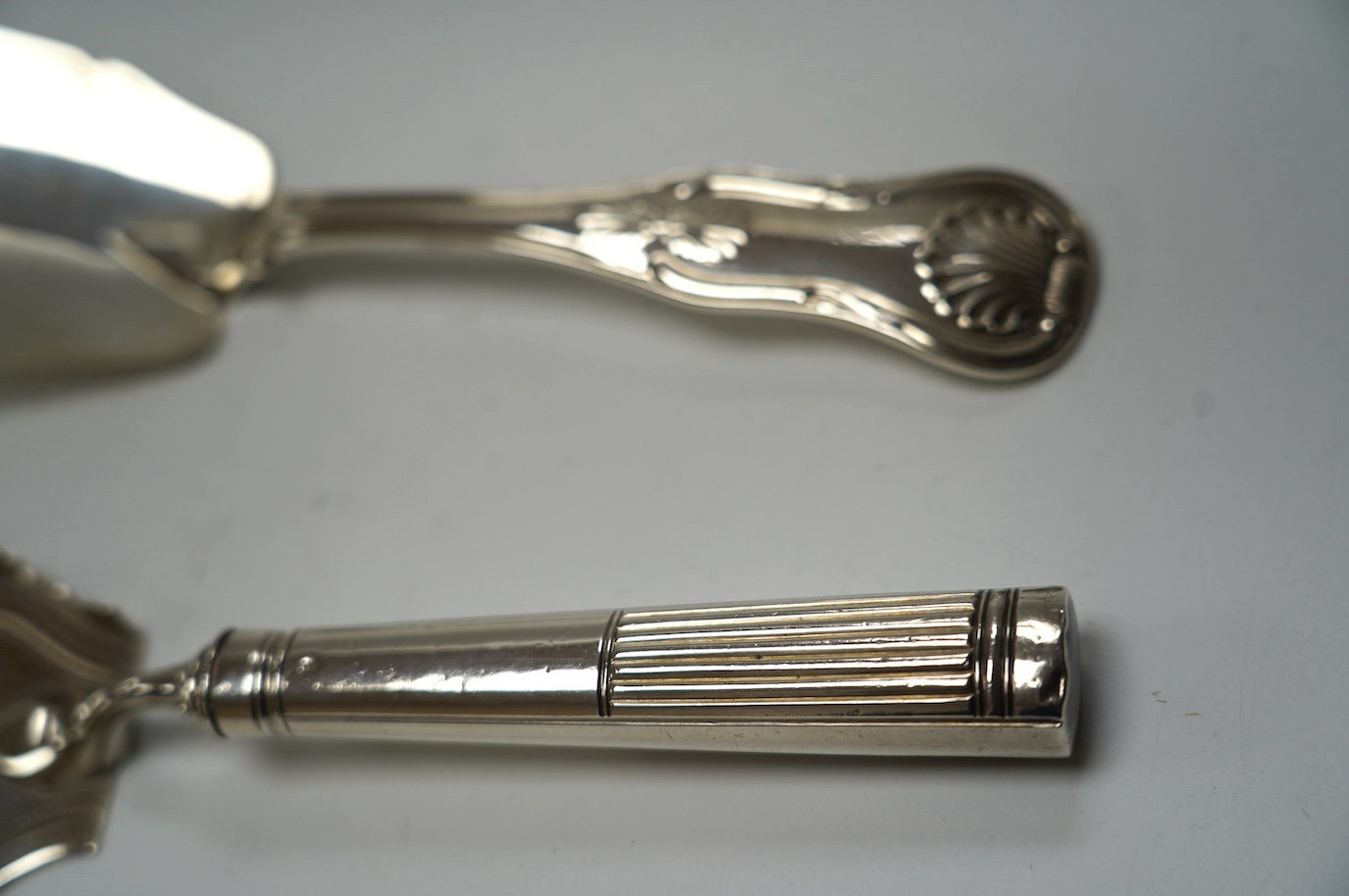 A George III silver fish slice with part gallery border, Henry Chawner, London, 1791, 30.4cm and a later George IV silver King's pattern fish slice, London, 1821. Condition - poor to fair